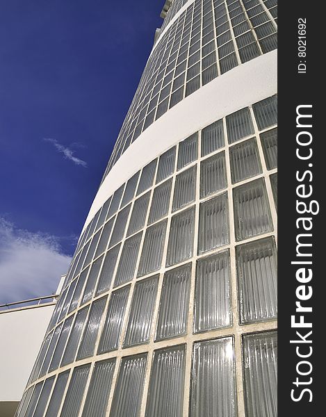 A modern curved glass building, and blue sky. A modern curved glass building, and blue sky