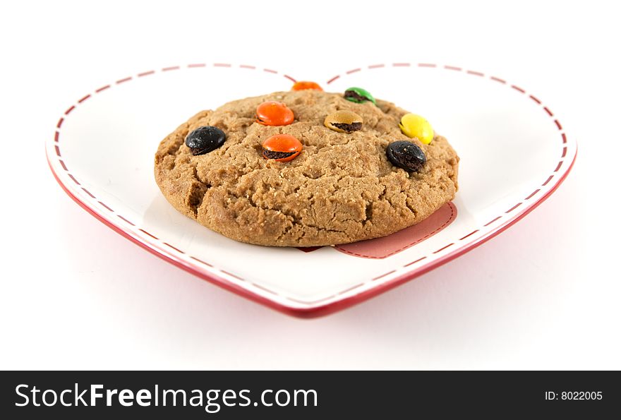 Cookie on heart shaped plate with shallow depth of field and isolated background.