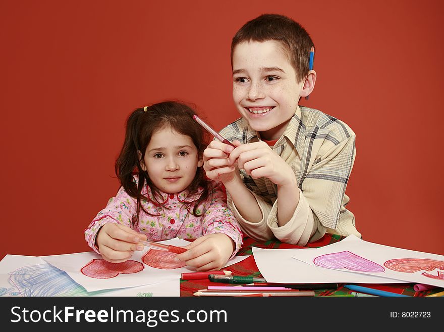 Sister and brother togetherness, children collectively drawing valentine hearts