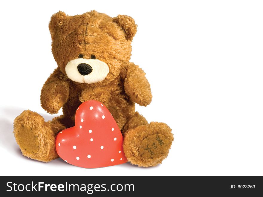 Brown teddy bear with red heart isolated on white background