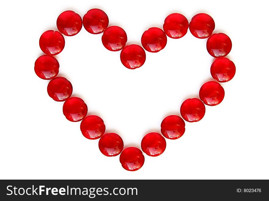 An image of a heart made by cristal beads in red over white