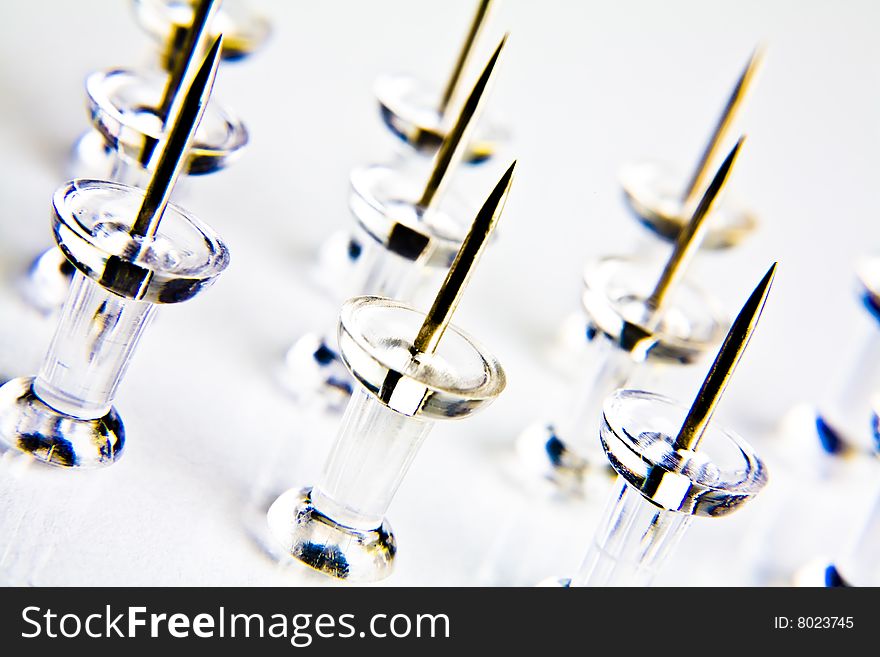 Macro photograph of thumbtacks on white