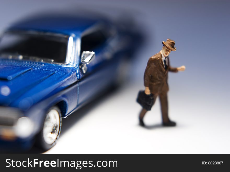 Businessman figurine with briefcase leaving a blue car. Businessman figurine with briefcase leaving a blue car