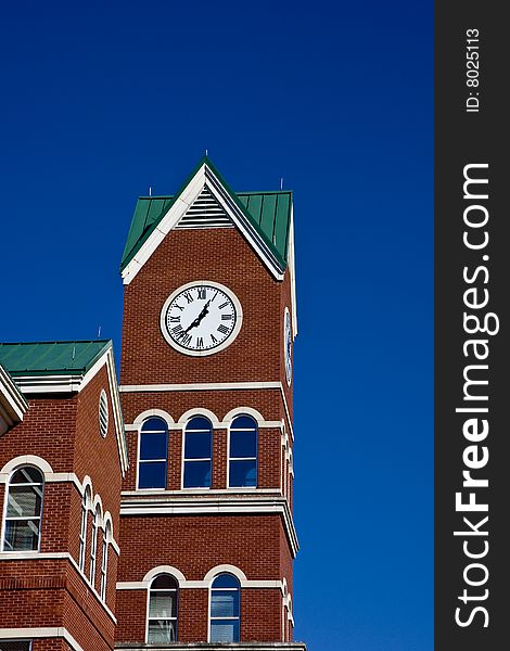 A clock on a brick building against a blue sky. A clock on a brick building against a blue sky