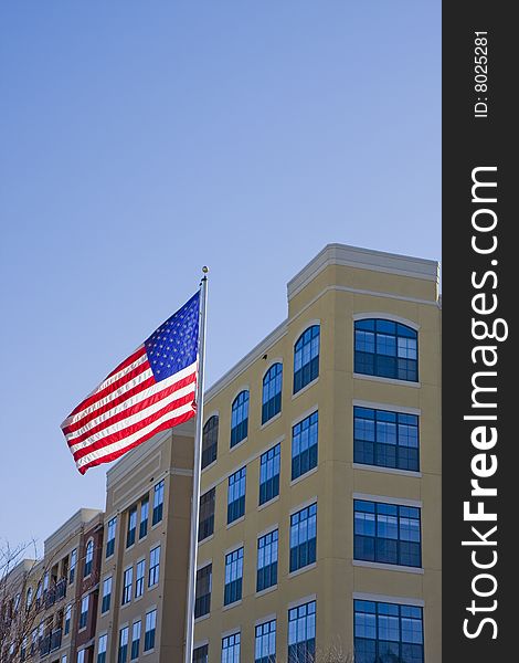 A high rise yellow stucco condo with an American flag against a blue sky. A high rise yellow stucco condo with an American flag against a blue sky