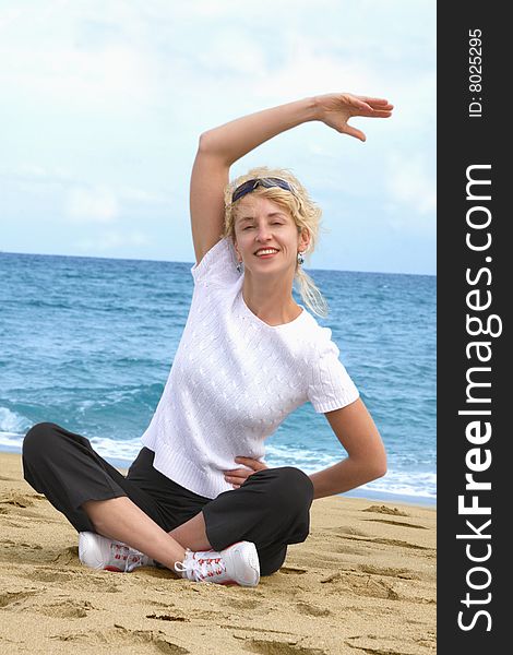 Blond girl exercising at sea beach