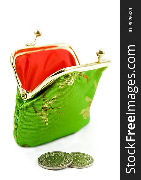 Green purse with some coins in front of it. Green purse with some coins in front of it