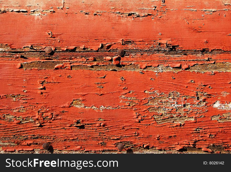 Red painted cracked wooden plank with rusty tacks. Red painted cracked wooden plank with rusty tacks
