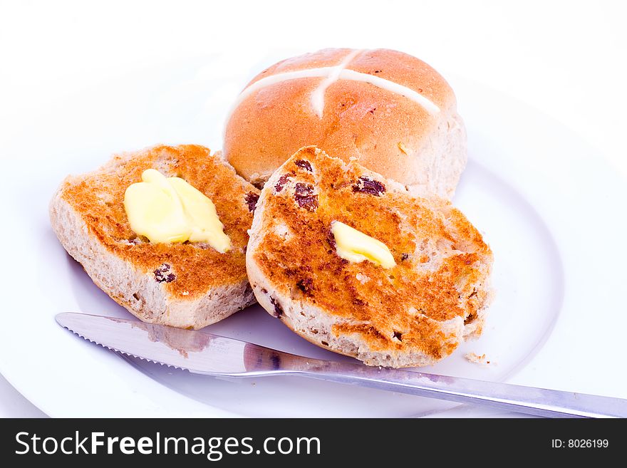 Freshly buttered plate of hot cross buns. Freshly buttered plate of hot cross buns