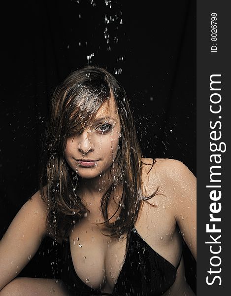 Portrait of woman taking a shower on black background. Portrait of woman taking a shower on black background