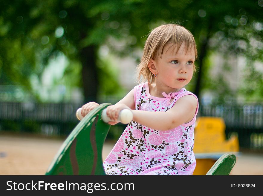 Small thoughtful beauty girl on spring swing. Hot summer. Small thoughtful beauty girl on spring swing. Hot summer.