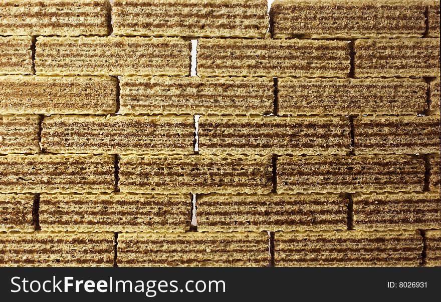 Food background texture - chocolate wafers arranged in rows, forming a sweet wall obstacle - sugar addiction.