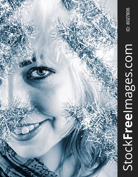 Winter portrait of a beautiful young smiling woman in blue tones