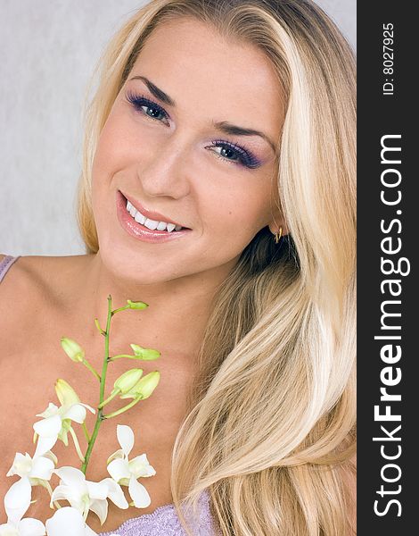 Blond girl with orchid in studio shot. Blond girl with orchid in studio shot