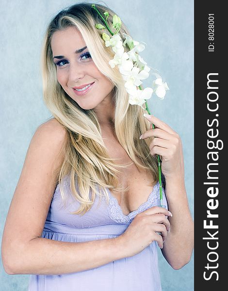 Blond girl with flowers in studio shot