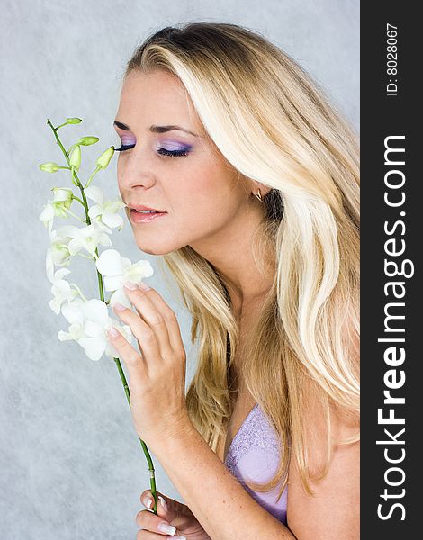 Blond girl with orchid in studio shot. Blond girl with orchid in studio shot