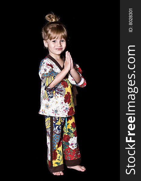 Little girl posing with a kimono over a black background. Little girl posing with a kimono over a black background