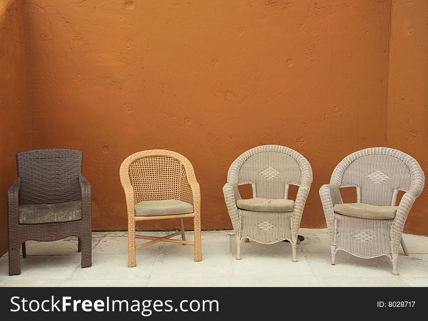 4 multiple wicker straw adirondack chairs against colorful bright background patio garden. 4 multiple wicker straw adirondack chairs against colorful bright background patio garden