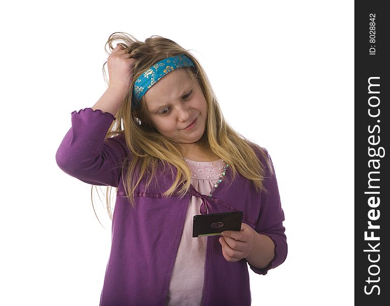 Young girl confused by an old floppy disc. Young girl confused by an old floppy disc