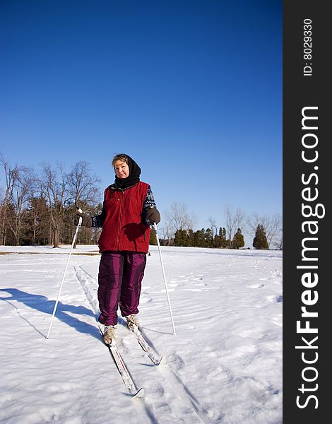 A Woman Cross Country Skiing Accross An Open Field