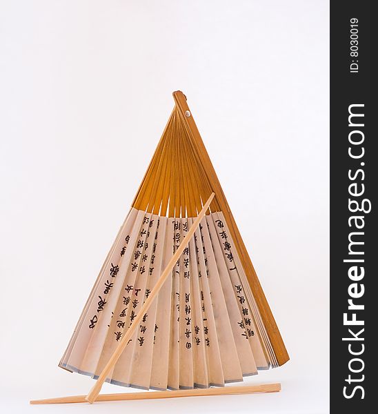 Fan and chopsticks on the white background