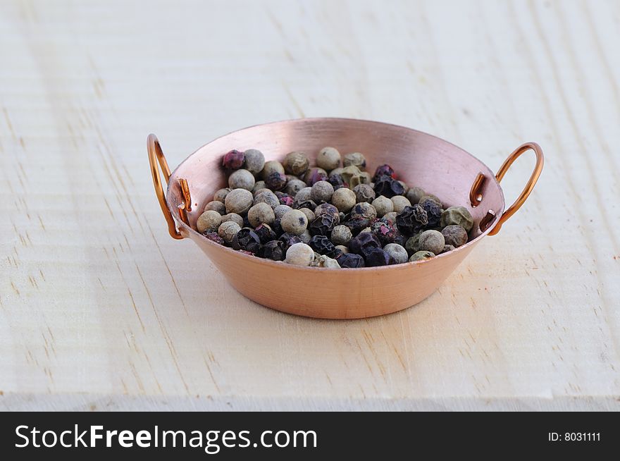 Picture of frying pan isolated in background of wood with pepper. Picture of frying pan isolated in background of wood with pepper