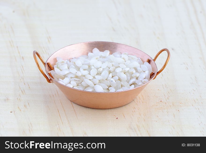 Picture of frying pan isolated in background of wood with rice. Picture of frying pan isolated in background of wood with rice