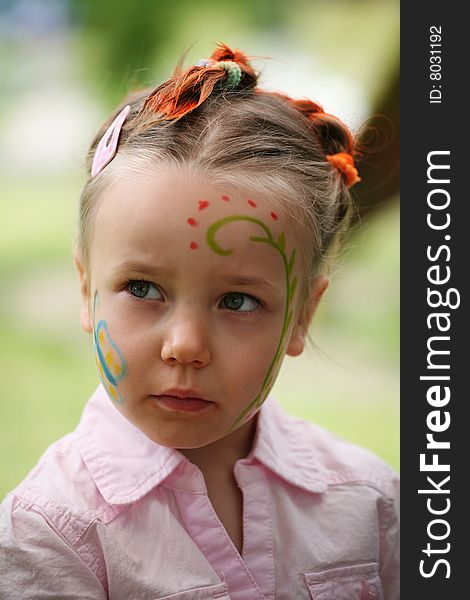 Cute outdoor portrait of five years old girl with face and hair painted. Cute outdoor portrait of five years old girl with face and hair painted.