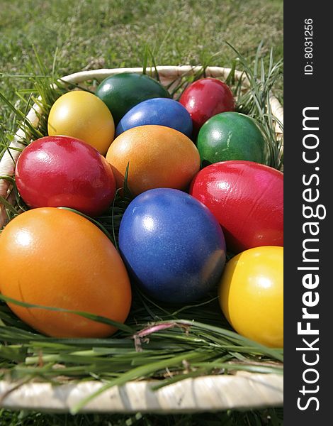 Easter eggs on a bascket with different color on the grass