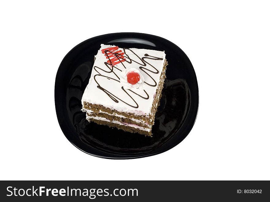 Cake with cherry on a black plate