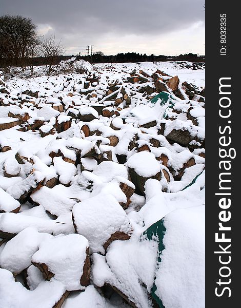 A pile of logs ready for cutting in the snow. A pile of logs ready for cutting in the snow