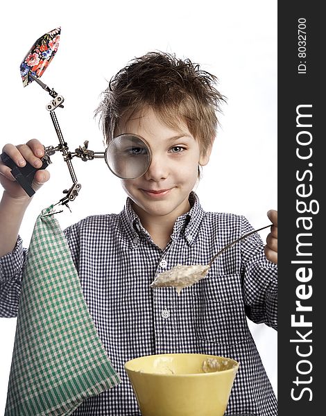 A boy with  a magniglass eating a sweet and porridge. A boy with  a magniglass eating a sweet and porridge