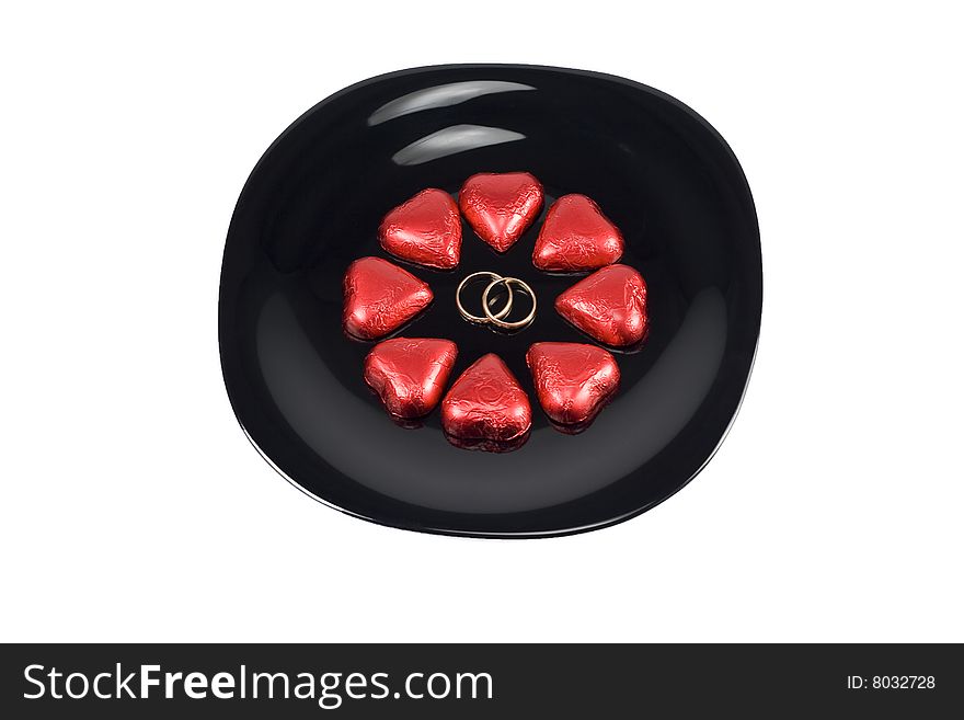 Hearts with wedding rings on a black plate