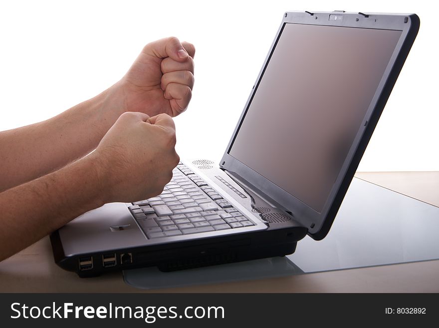 Two fists show anger in front of laptop on a table. Isolated over white background. Copyspace also on the screen. Two fists show anger in front of laptop on a table. Isolated over white background. Copyspace also on the screen.