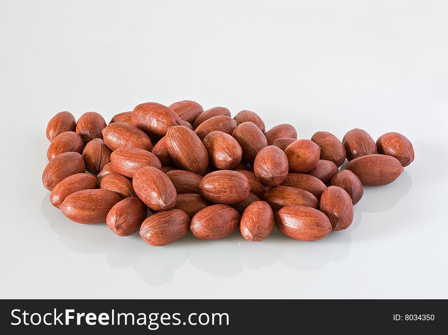 Pile of pecan nuts against a grey background