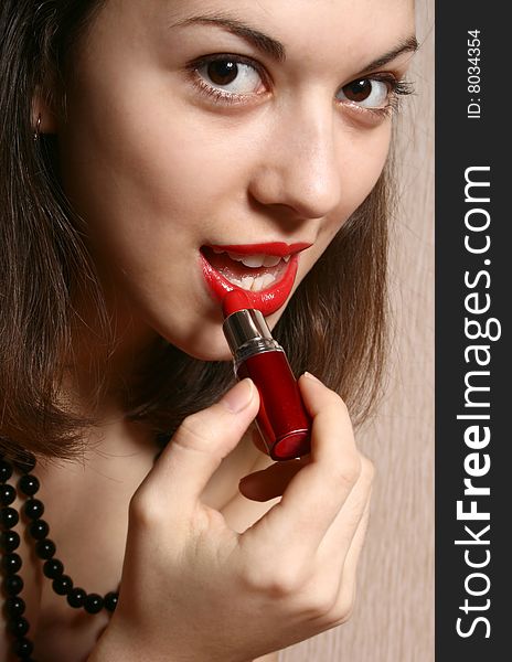 Close up of the girl which paints lips with red lipstick. Close up of the girl which paints lips with red lipstick.