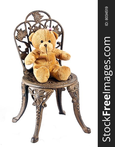 Teddy Bear sitting on old garden chair isolated on white