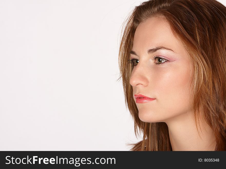 Pretty girl looking sideways with long brown hair and pink makeup. Pretty girl looking sideways with long brown hair and pink makeup