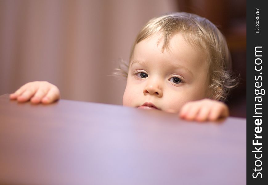 Little girl looking out of a table - shallow DOF