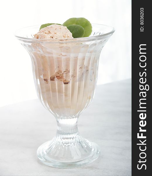 Vase with ice-cream on background