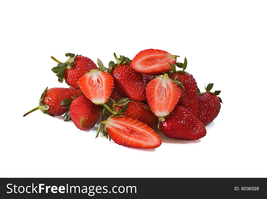 Pile of whole strawberrys with four halfs against a white background