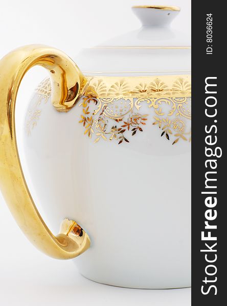 Ornate teapot handle with gold filigree and gold plate.