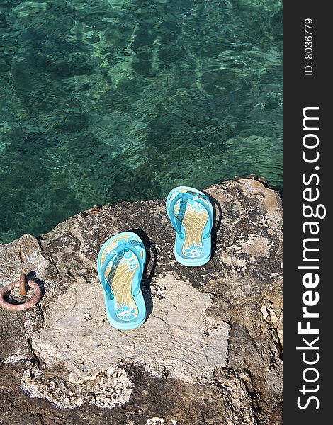 Adriatic sea and slippers on the beach, summer vacation