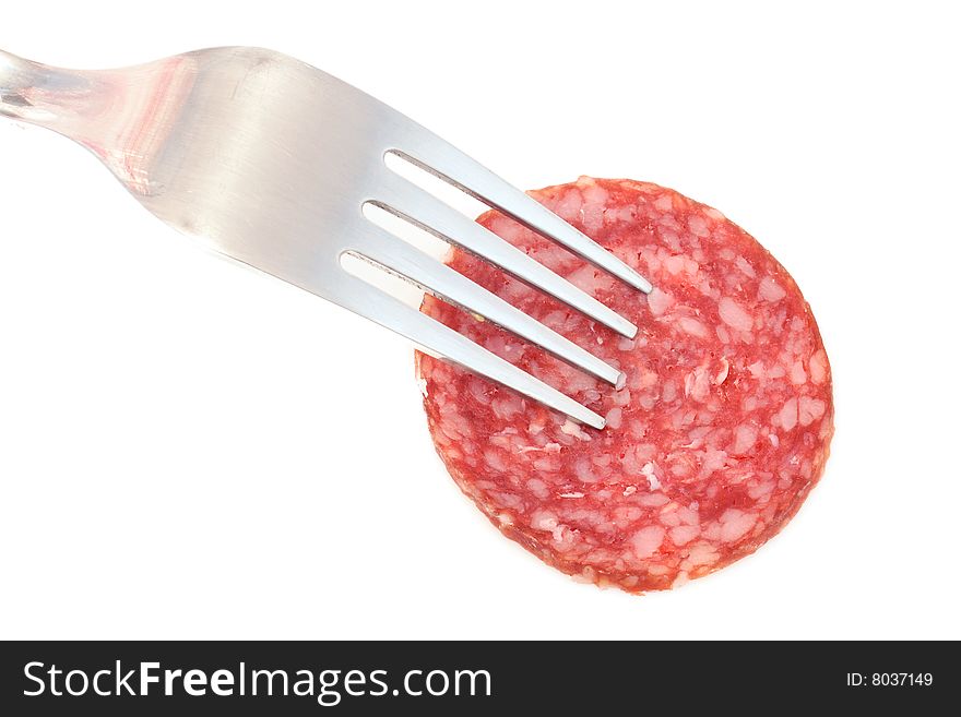 Piece of the sausage on the fork under the white background