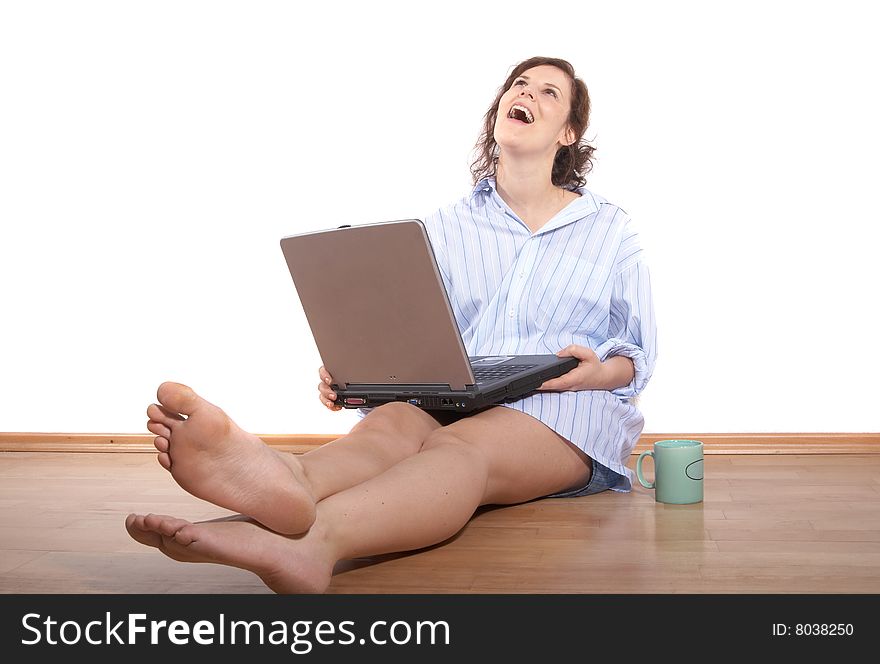 A young woman with a laptop on the floor at home. A young woman with a laptop on the floor at home.