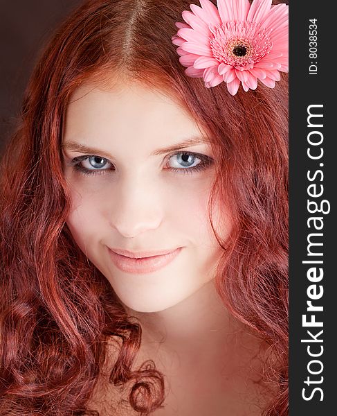 Young beautiful girl with a flower in hair