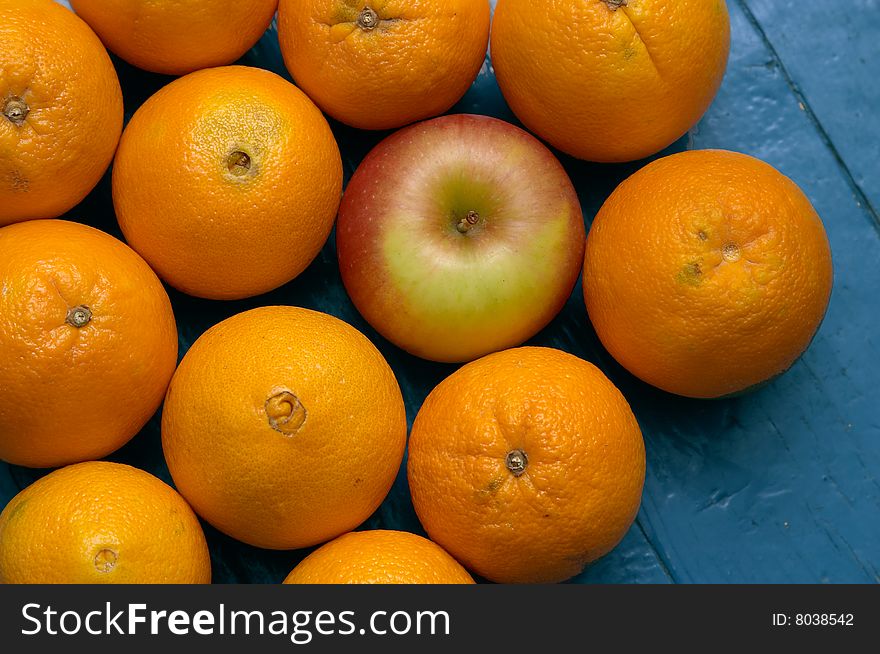 Group of orange with apple on blue wood parkets