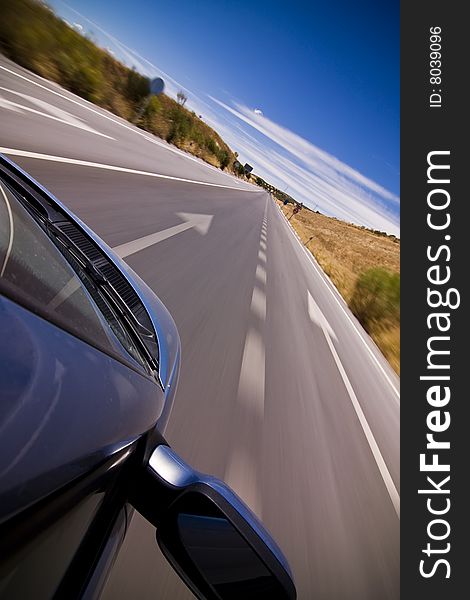 Cruising the countryside in a blue car at high speed.