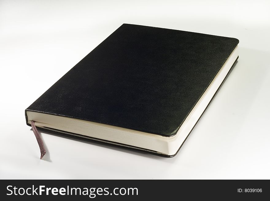 One black notebook with soft shadow on white background. One black notebook with soft shadow on white background