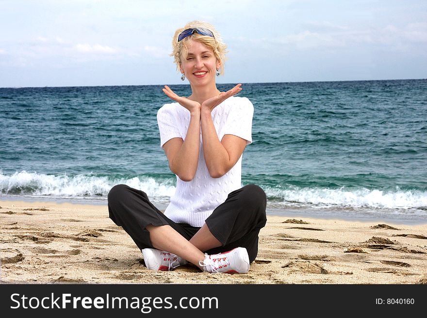 Blond girl meditating by the sea